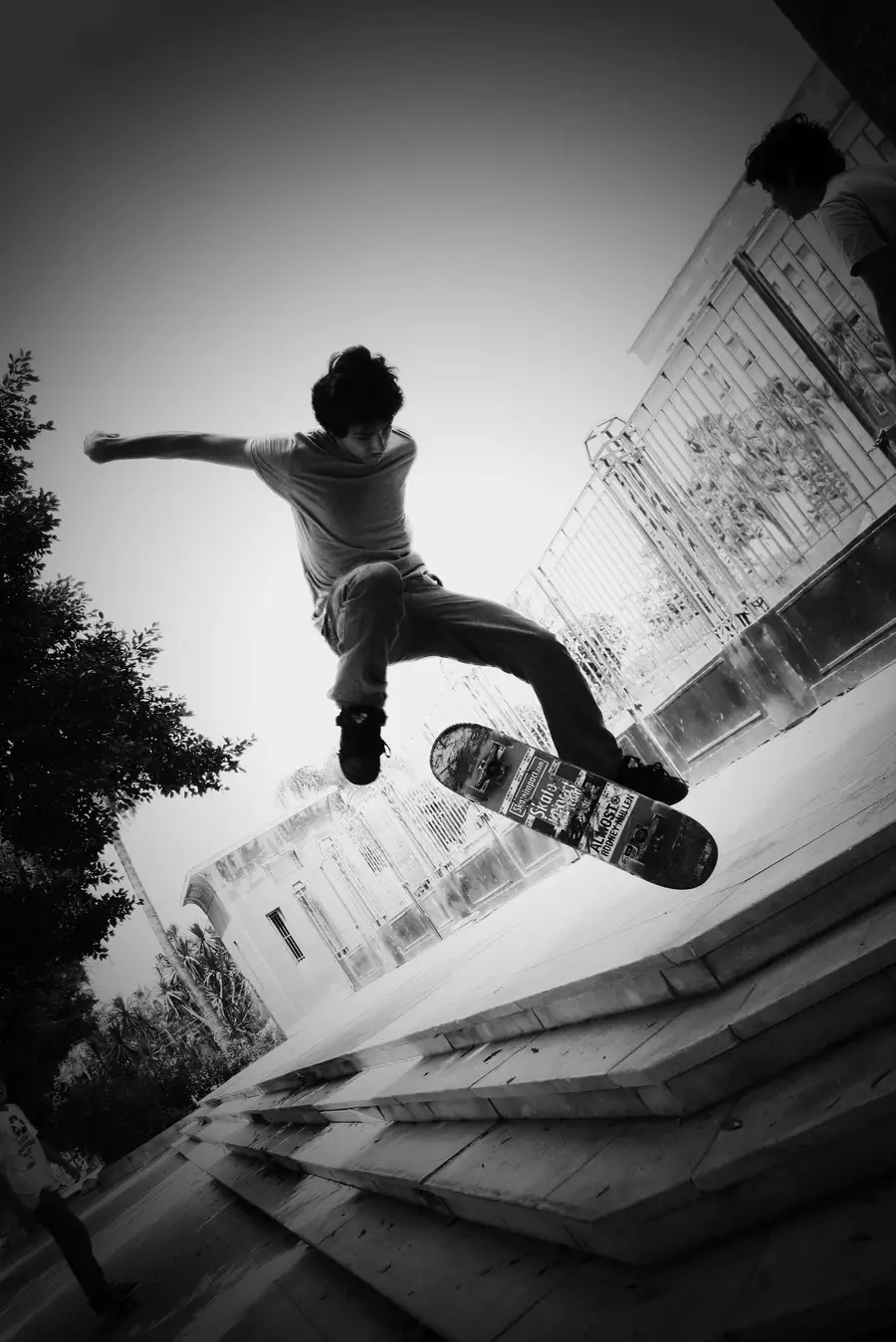 Skater mid-kickflip over a set of concrete steps
